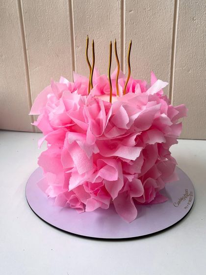 A full view of the stunning cake covered in edible pink ruffles, a true centerpiece for any celebration.