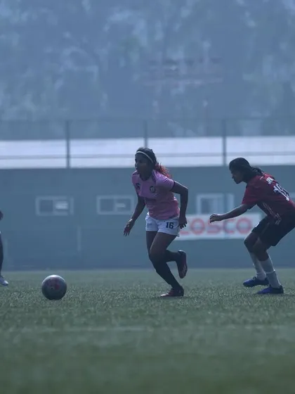 A player dribbling through midfield in foggy conditions, showing focus and determination.