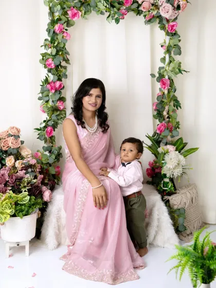 A sweet portrait of a mother and son sitting together, with the boy holding onto his mom's arm.