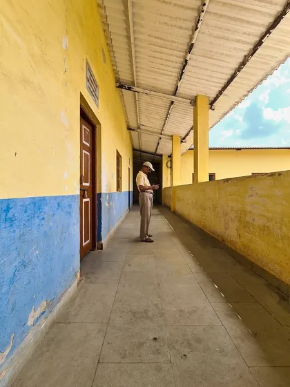 A man stands alone in a long, colorful corridor, absorbed by his phone. This candid shot uses leading lines to draw the viewer in and tells a quiet story of modern life.