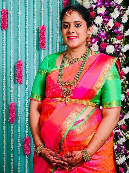 A beautiful portrait of the glowing mother-to-be, Advithi. Her smile and the vibrant saree light up the frame.