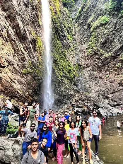 Our large group posing for a photo at the base of Koodlu Theertha falls during a coastal trip.