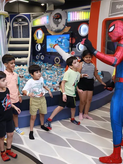 Watch your child's face light up when their favorite hero joins the party. Here, Spiderman interacts with a group of excited kids right in front of our space-themed play structure.