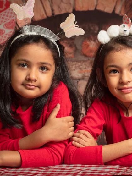 A collection of happy kids enjoying my two distinct Christmas setups: a bright, snowy winter scene and a warm, rustic brick fireplace.