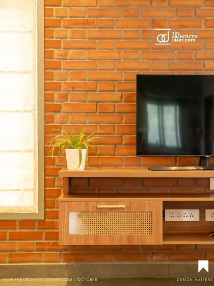 A detail shot of the TV unit in the Vivek Residence, showing the combination of exposed brick and cane-fronted wooden furniture.