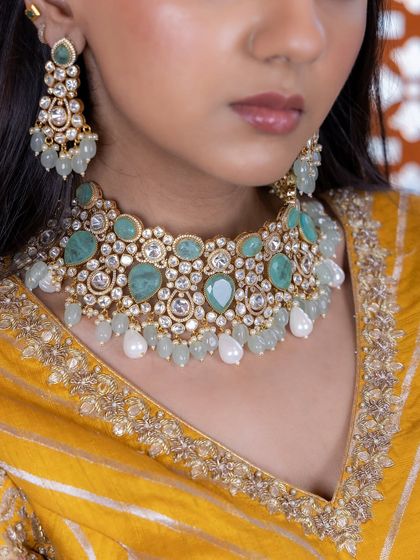 A close-up of the mint green and pearl Kundan choker. This image details the arrangement of the stones and pearls, showing the quality and care that goes into each piece.