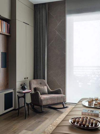 A quiet corner in the family lounge, featuring a comfortable rocking chair next to the window. This space is designed for moments of pause, perfect for enjoying a cup of tea and looking out at the view.