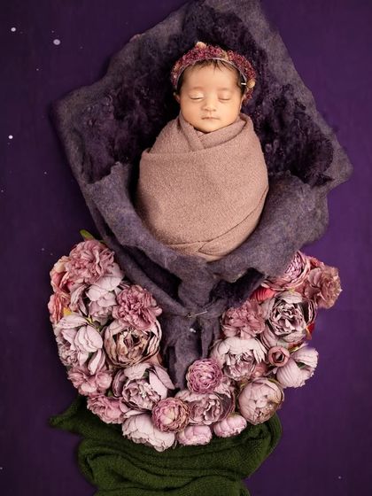 A creative composite photo where the swaddled newborn appears to be the bud of a beautiful flower. This is a unique way to create a fantasy portrait for your baby.