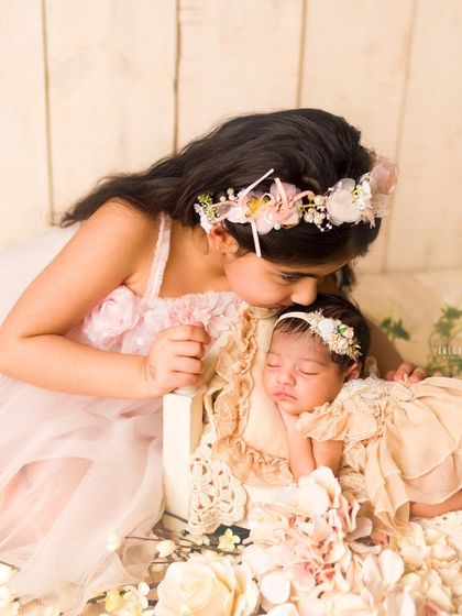 A gentle kiss for the new baby. This image captures the beginning of a beautiful sibling bond in a soft, dreamy setting.