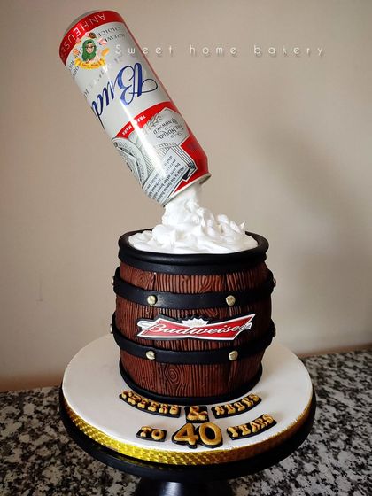 Cheers to 40 years! This gravity-defying beer barrel cake is perfect for a beer lover's milestone birthday. The design features an edible wood-grain barrel and a Budweiser can appearing to pour foam into it.