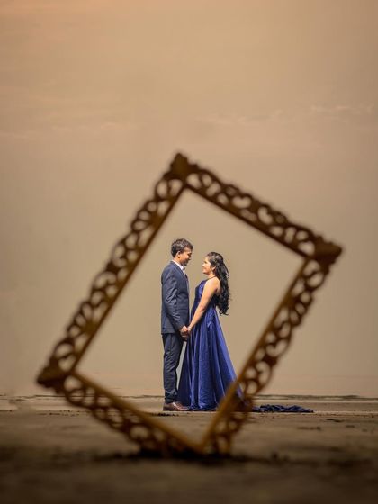 A creative shot using a frame to highlight the couple against the beach backdrop. This adds an artistic and personal touch to your pre-wedding photography.