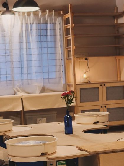 Our custom designed pottery wheels are set into a large communal table, which encourages conversation and learning from each other as you work.