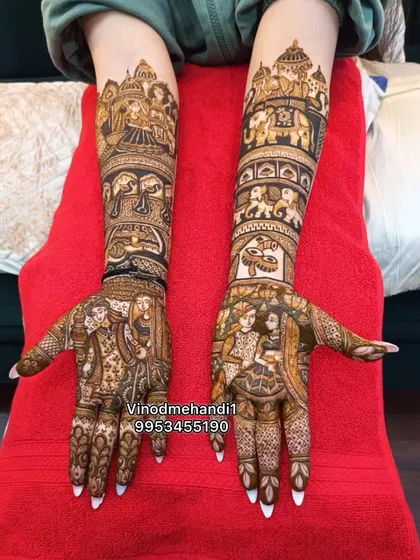 A stunning example of full-arm story mehendi. This design features multiple scenes, from the groom on an elephant to the bride in a doli and the couple's portrait.