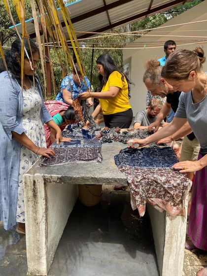The washing process is a crucial step. Here, workshop participants wash their freshly printed fabrics to reveal the final colors and patterns, a moment of excitement and discovery.