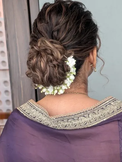 A hairstyle is the crown of any bridal look. This intricate messy bun, woven with fresh jasmine flowers (gajra), is a perfect example of how I blend traditional elements with modern styling. It’s designed to be secure, comfortable, and beautiful from every angle.