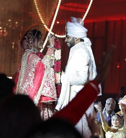 The jaimala exchange is a moment of pure happiness. Here, the couple is surrounded by their cheering family and friends as they complete the ritual, with sparks from the pyrotechnics adding to the celebration.