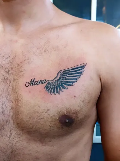 A name tattoo personalized with a guardian angel wing. This design is a beautiful way to remember or honor someone special.