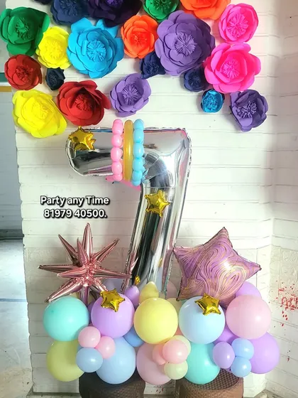 A colorful 7th birthday bouquet with pastel balloons and paper flower backdrop.