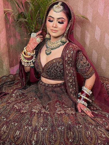 Our bride looks absolutely radiant in this maroon bridal lehenga. The heavy jewelry perfectly complements the intricate work on the outfit.