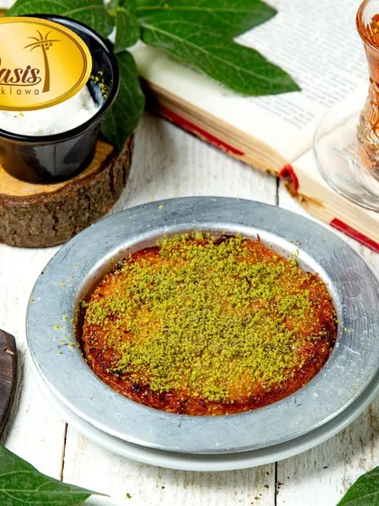 Our authentic Kunafa, served warm with a generous sprinkle of pistachios. This traditional dessert features a creamy, cheesy center and a crispy, golden-brown pastry crust.