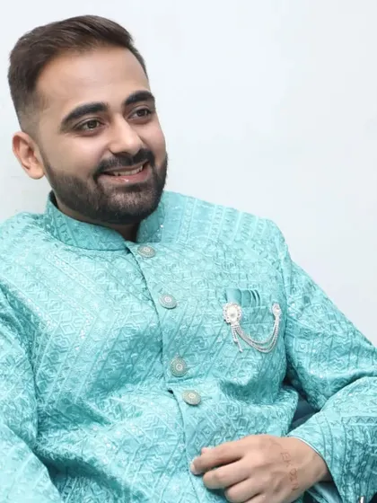 A relaxed groom sitting and smiling. The makeup is designed for comfort, allowing you to feel at ease throughout your wedding events.