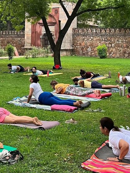 The community practicing Bhujangasana, or cobra pose, together on the grass.