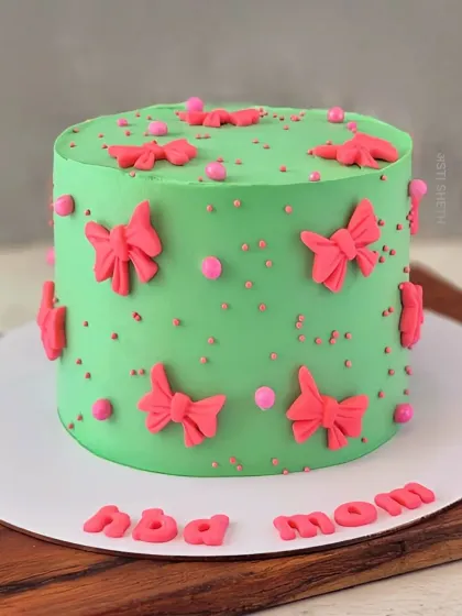 A bright and cheerful cake for mom, decorated with pink bows on a green whipped cream base. This is a Chocolate Vanilla cake with exotic mixed berries.