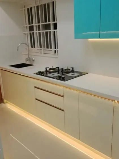 A look at a modern kitchen layout we completed, showcasing a clean and efficient workspace. This design features dual-tone cabinetry, a durable white countertop, and integrated floor and under-cabinet lighting that makes the space feel bright and spacious while providing excellent task illumination.