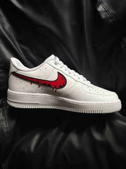 A side profile of the red drip custom sneaker.