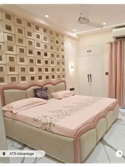 A soft and glamorous bedroom with a pink and cream color scheme. The accent wall features a grid of 3D mirrored squares, adding texture and a touch of sparkle.