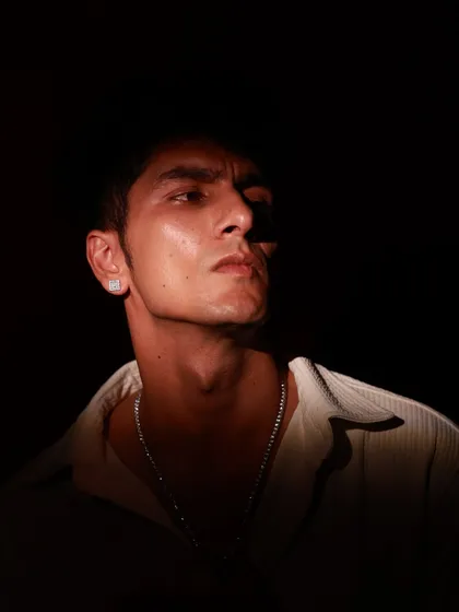A dramatic, moody male portrait using high-contrast lighting to sculpt facial features against a dark background. This shows my versatility in capturing intensity and character in men's portraiture.