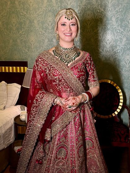 A full-length shot of Vanessa in her stunning red and pink lehenga. She looks absolutely regal and elegant.
