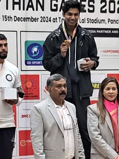 One of our fighters proudly displaying his gold medal on the winner's podium at the Pythian Games 2024.