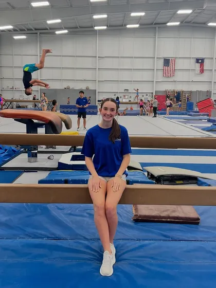 We believe in celebrating our AWESOME team! Here's one of our fantastic coaches, with a student in the background mastering a back handspring on the tumble track. Our coaches are here to guide and support every child through their fitness journey.