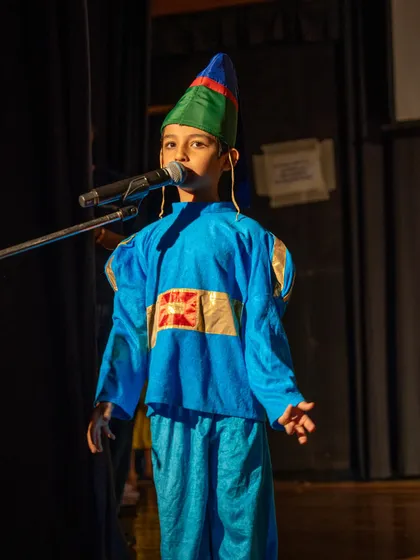 A young actor confidently delivering his lines at the microphone, a key skill for public speaking and performance.