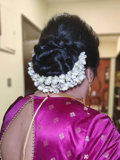 A classic bridal bun adorned with a full gajra of fresh jasmine flowers. The fragrance and beauty of this traditional hairstyle are simply unmatched for a wedding ceremony.