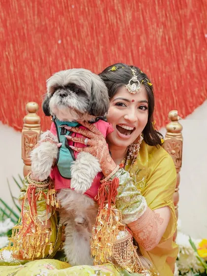 A heartwarming and candid moment as the bride shares her Haldi ceremony seat with her beloved dog. This photo shows that even pets are a cherished part of the wedding celebration.
