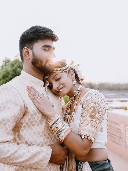 A soft and romantic moment captured in the golden hour light. The bride-to-be rests her head on her partner's shoulder, creating a feeling of peace and love.