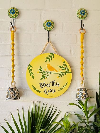 Another one of our six amazing wall setup ideas. This one features our 'Bless This Home' wooden hanging, paired with two yellow macrame ceramic bells for a cheerful and positive entrance.