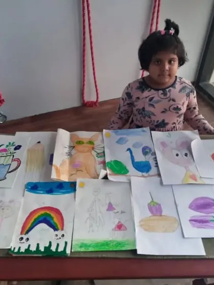 This is Nataniya, one of our 6-year-old students, with a selection of her work. Even at a young age, she has explored everything from rainbows and cartoons to still life drawings of vegetables.
