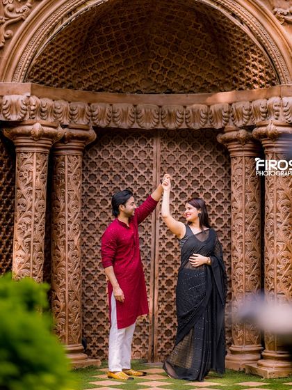 A couple dances in front of the intricately carved wooden doors, a perfect setting for a traditional and elegant pre-wedding photo.