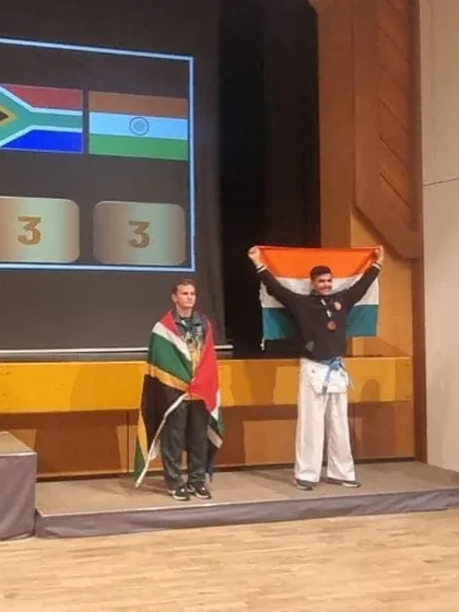 Shandai Manan Parekh on the podium, holding the Indian flag high after winning a bronze medal at the WGKF World Goju Ryu Karate Championship. A moment of immense pride for our nation and our academy.