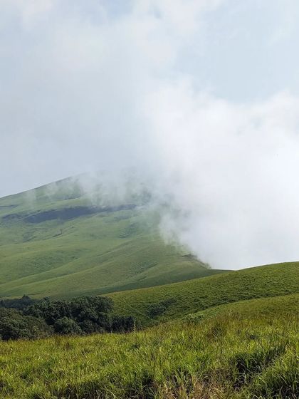 A view of the Nethravathi peak partially covered in clouds, a typical and beautiful winter scene.