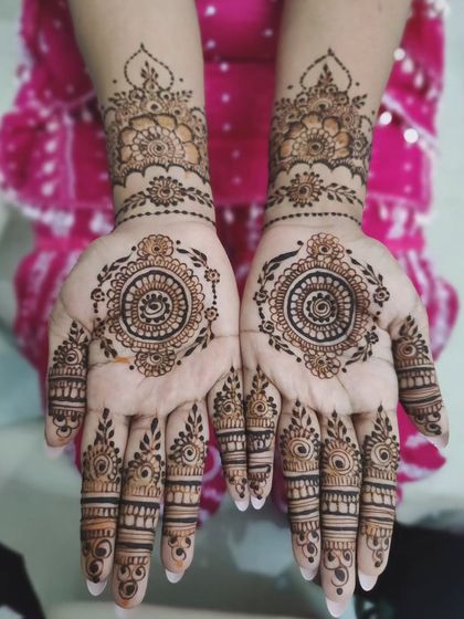 This design is all about symmetry and detail. Both hands feature a central mandala surrounded by delicate patterns and intricate finger work, creating a balanced and beautiful look.