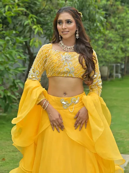 A full-length shot of a model in a vibrant yellow lehenga, perfect for a mehendi or haldi ceremony. This shows how my jewellery can be styled for fun, festive pre-wedding events.
