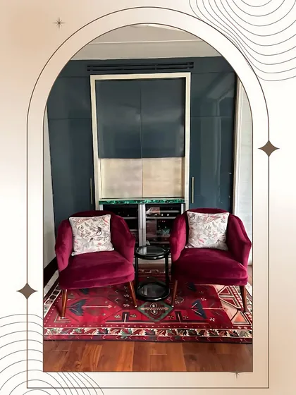 This cozy lounge area is part of a larger bedroom suite, featuring plush velvet armchairs and a hidden bar cabinet. It’s the perfect spot for a quiet evening drink or intimate conversation.