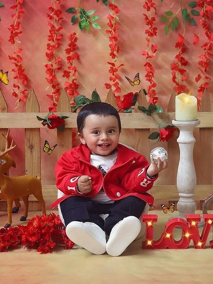 Spreading the love with a Valentine's themed sitter session. This little boy in his red jacket looks so handsome against the romantic red backdrop with woodland creatures.