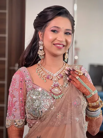 A close-up of the bride's happy face, her makeup perfectly complementing the pastel tones of her outfit.