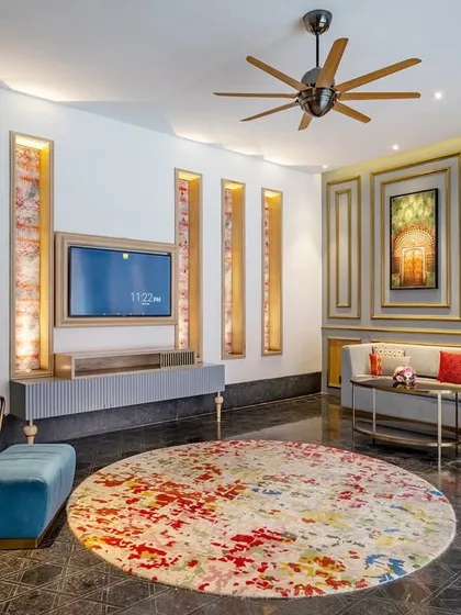 The living area of a suite at Taj Devi Ratn, featuring a custom circular rug that grounds the space with a splash of color. I used elegant wall moulding and curated art to blend classic European design with vibrant Indian aesthetics.