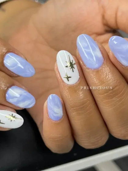 This is what a dreamy set looks like. It combines a soft lavender marble with a solid white accent nail featuring gold celestial charms.